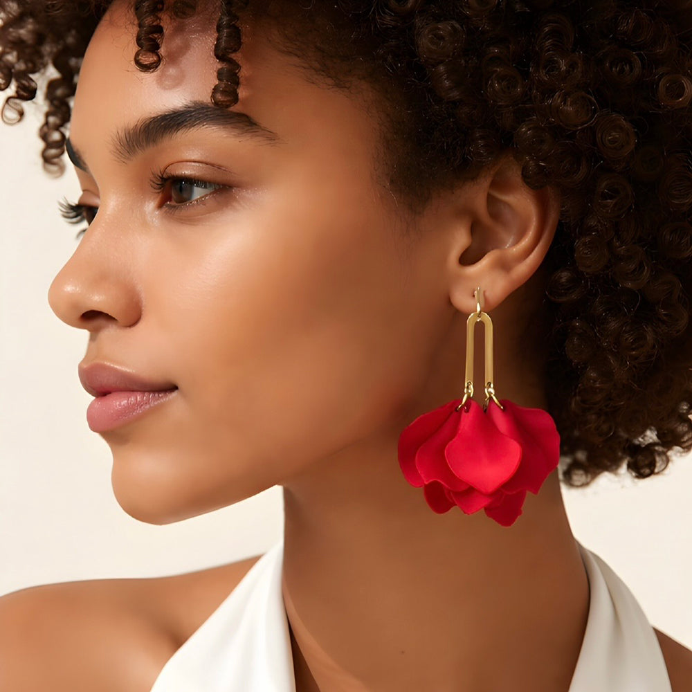 Red petal-shaped earrings with gold hooks on a white background