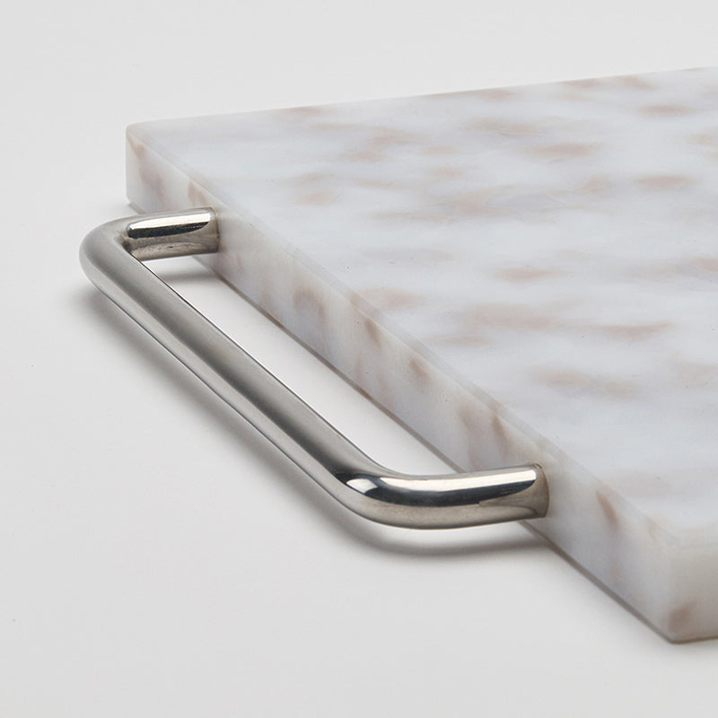 Marble tray with a silver handle on a light gray background
