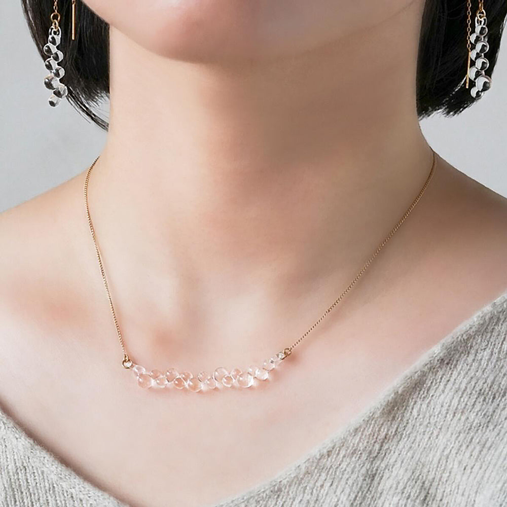 Close-up model wearing necklace.
