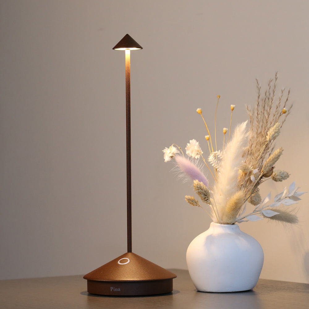 Pina lamp on table with floral arrangement.