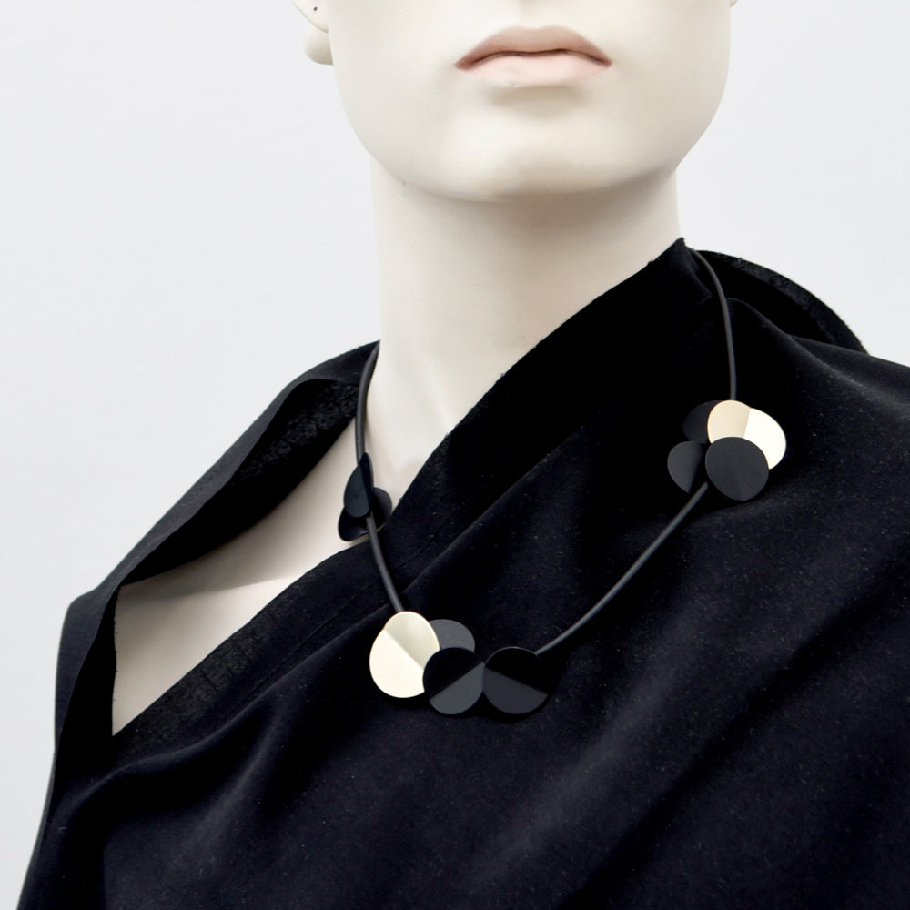 Styled image of necklace on black fabric.