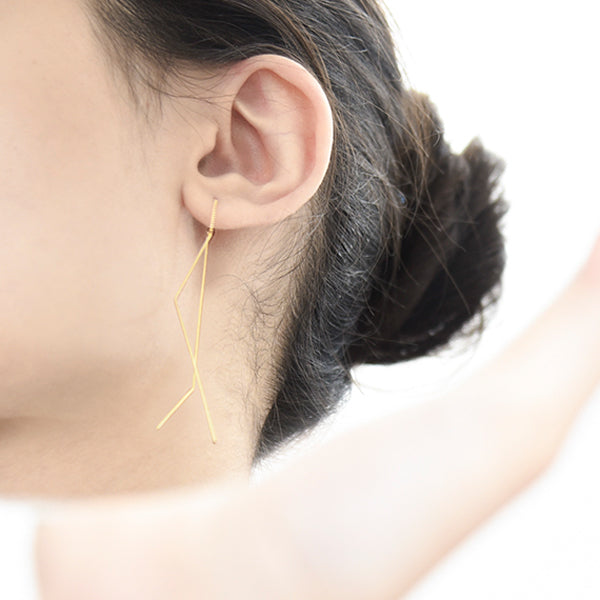 Lifestyle image of slender gold bar earrings