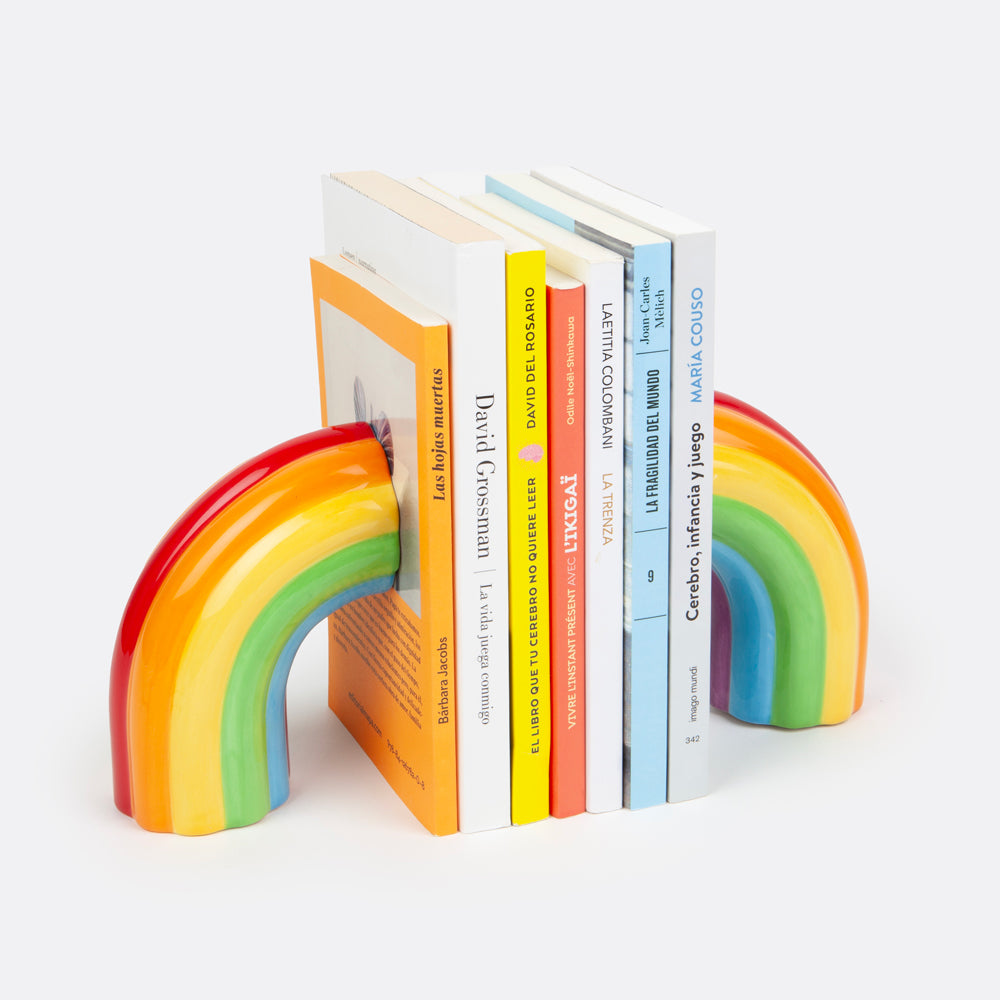 A pair of multicolored rainbow-shaped ceramic bookends designed to hold books upright on a shelf.