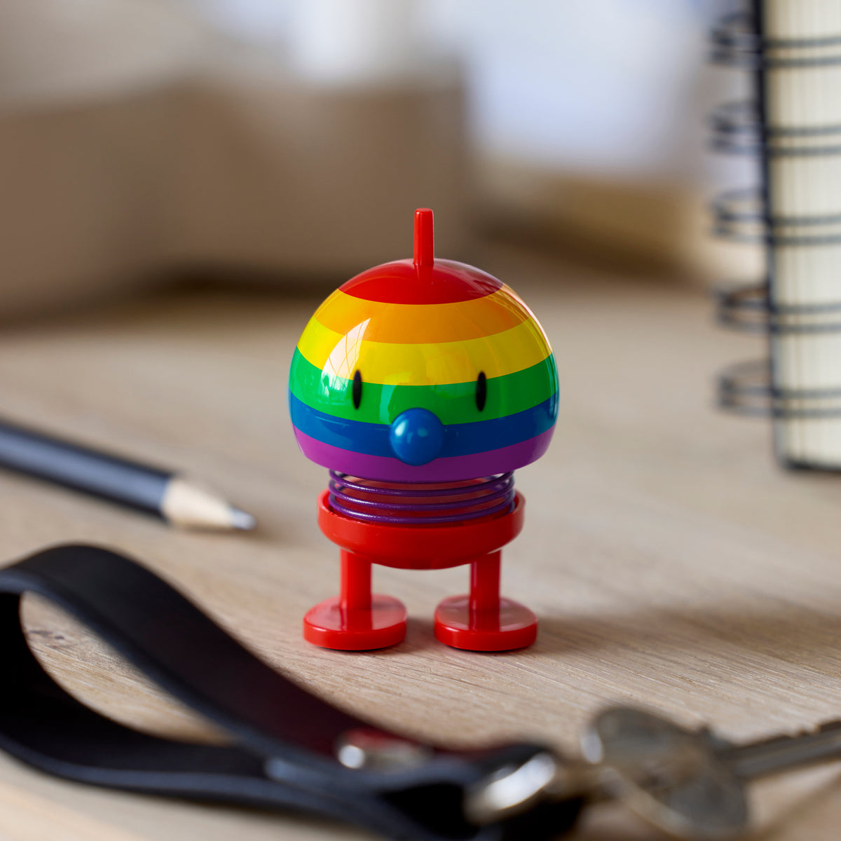 Colorful Hoptimist with rainbow stripes on a desk