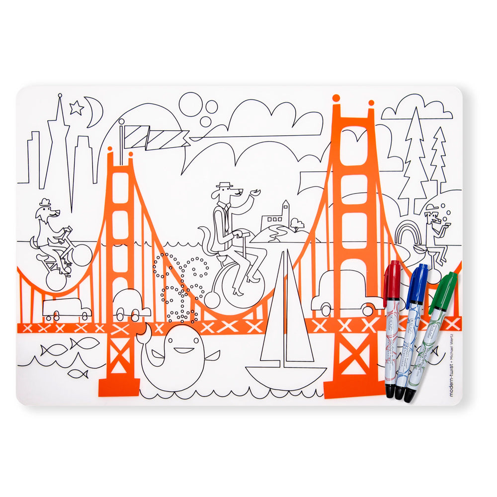 A white mat featuring a black-and-white line art illustration of the Golden Gate Bridge with colorful orange bridge sections, plus three markers placed on the lower right edge.
