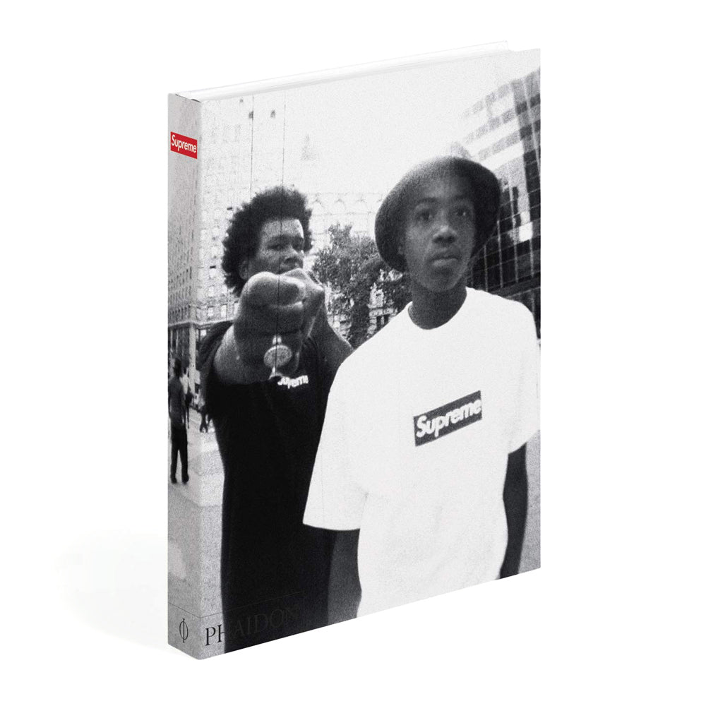 Book or magazine cover with two people wearing Supreme clothing, featuring the brand logo.
