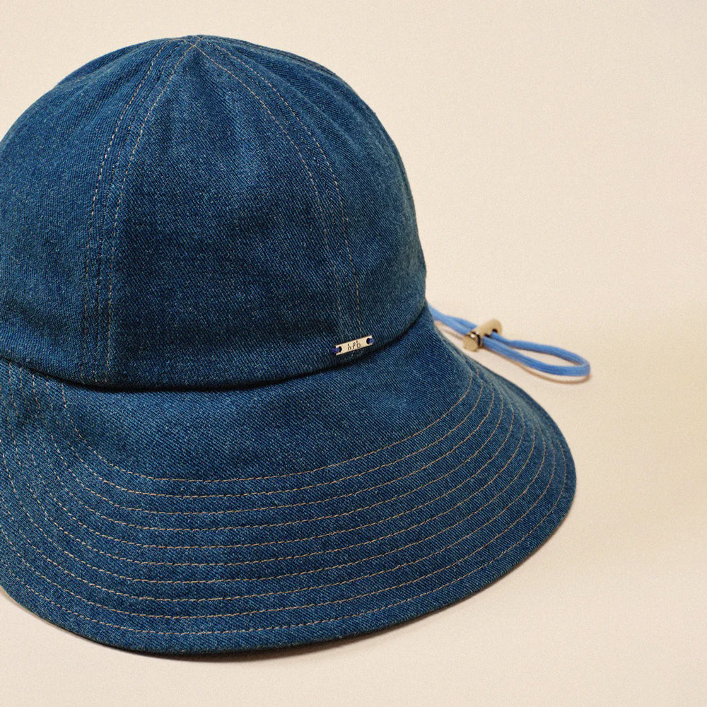 Blue denim bucket hat with a strap on a beige background