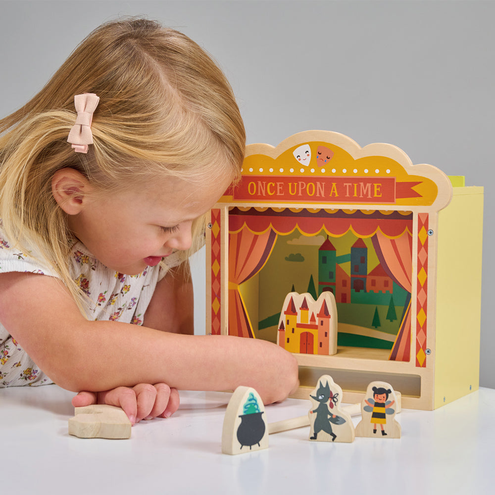 Child playing with wooden theatre.
