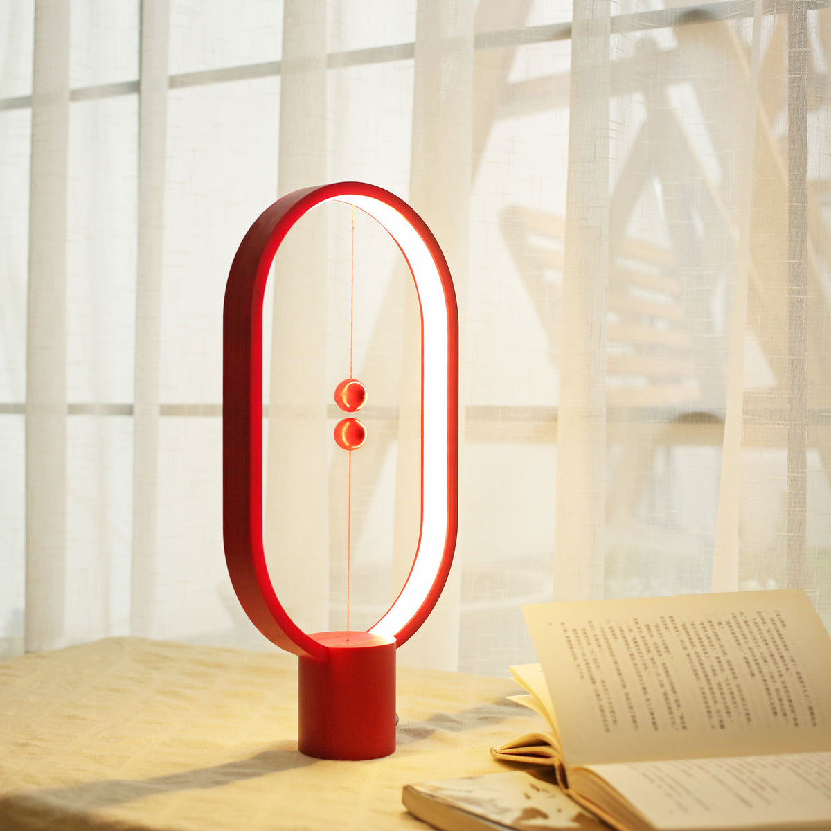 The Heng Balance Lamp lighting a book on a table.