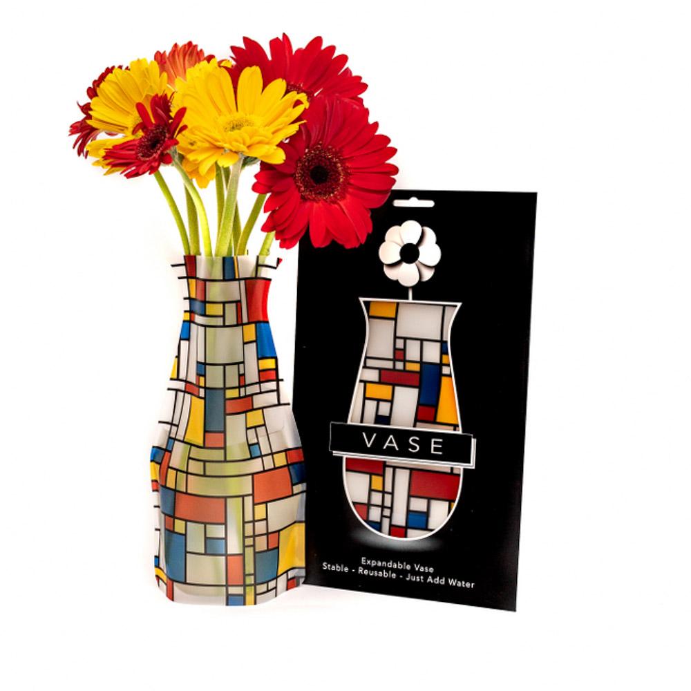 The Mona Vase with flowers displayed next to its packaging.