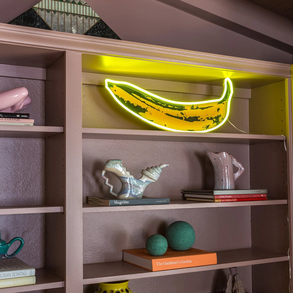 Banana light on shelf with objects with books.