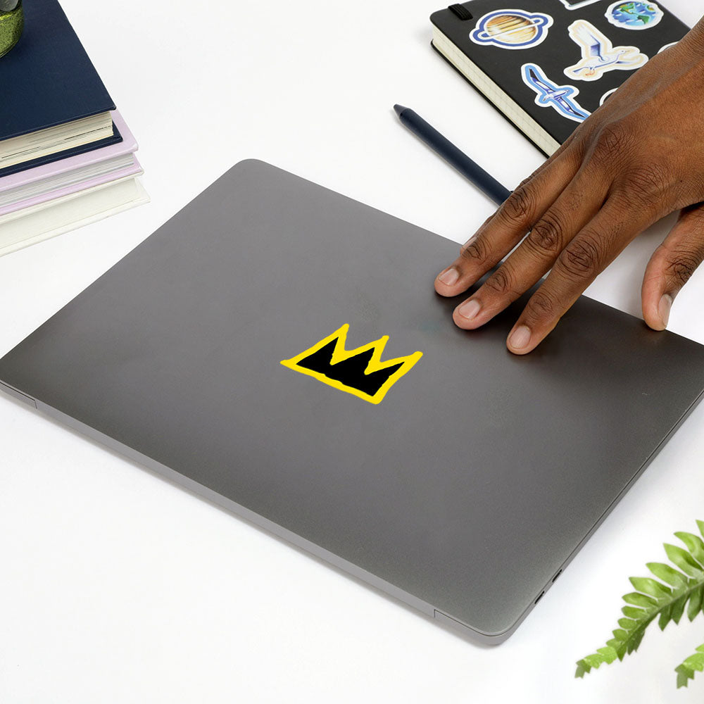 Model reaching for laptop with Basquiat Crown Sticker by Apply Stickers.