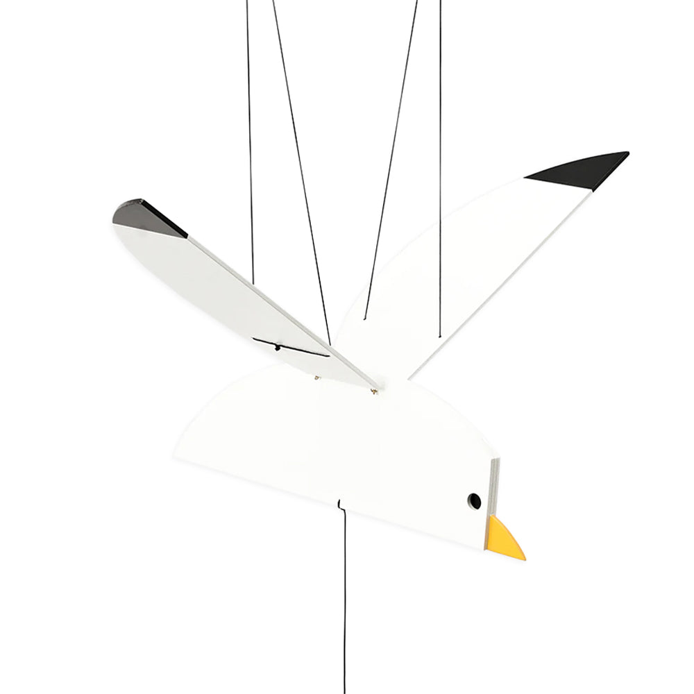 Wooden seagull mobile, painted white with black wing tips and yellow beak, hanging from black strings.Wooden seagull mobile, painted white with black wing tips and yellow beak, hanging from black strings.