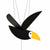 Wooden toucan mobile, painted black with white face and yellow beak, hanging from black strings.