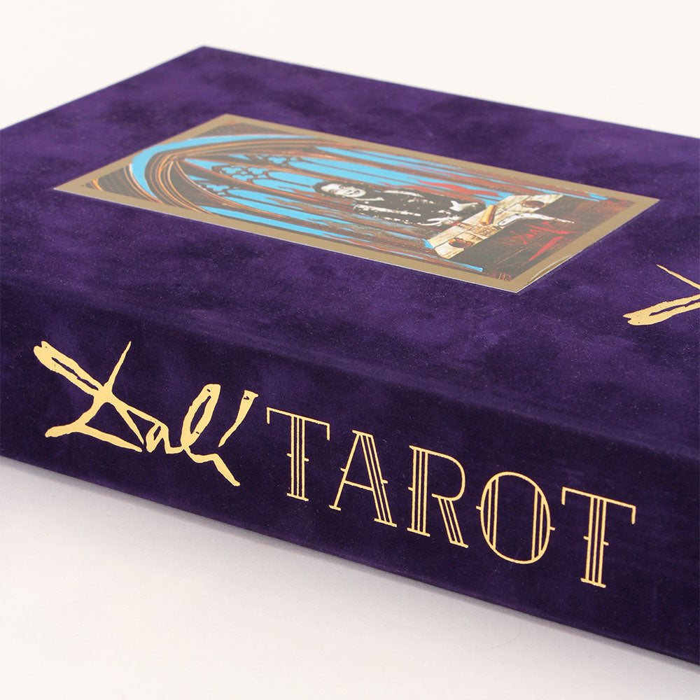Cover of 'Dali Tarot.' Purple cover with gold text, featuring full color surrealist illustration of Dali in a burning chapel.