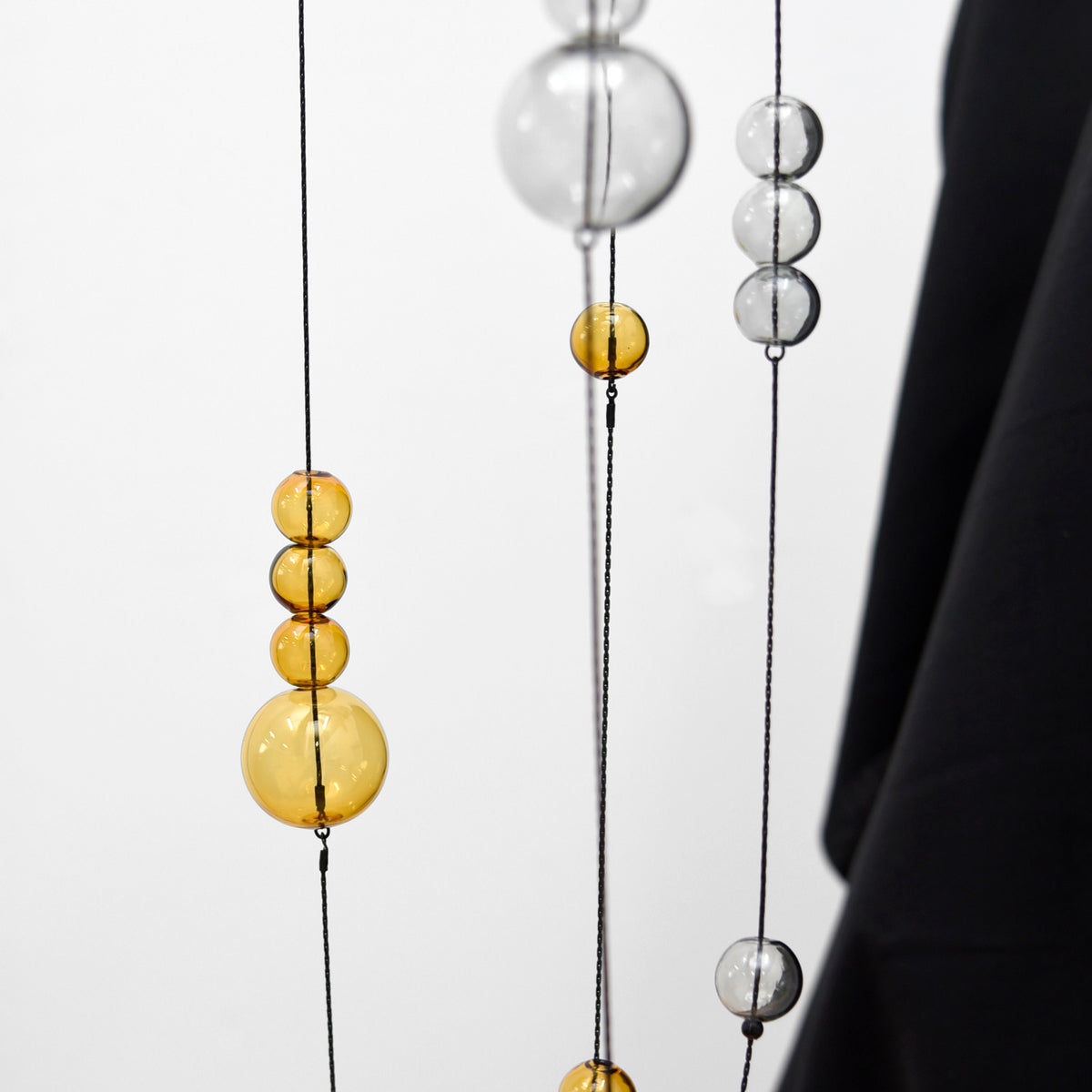 Hanging grey and gold glass bubble necklaces.