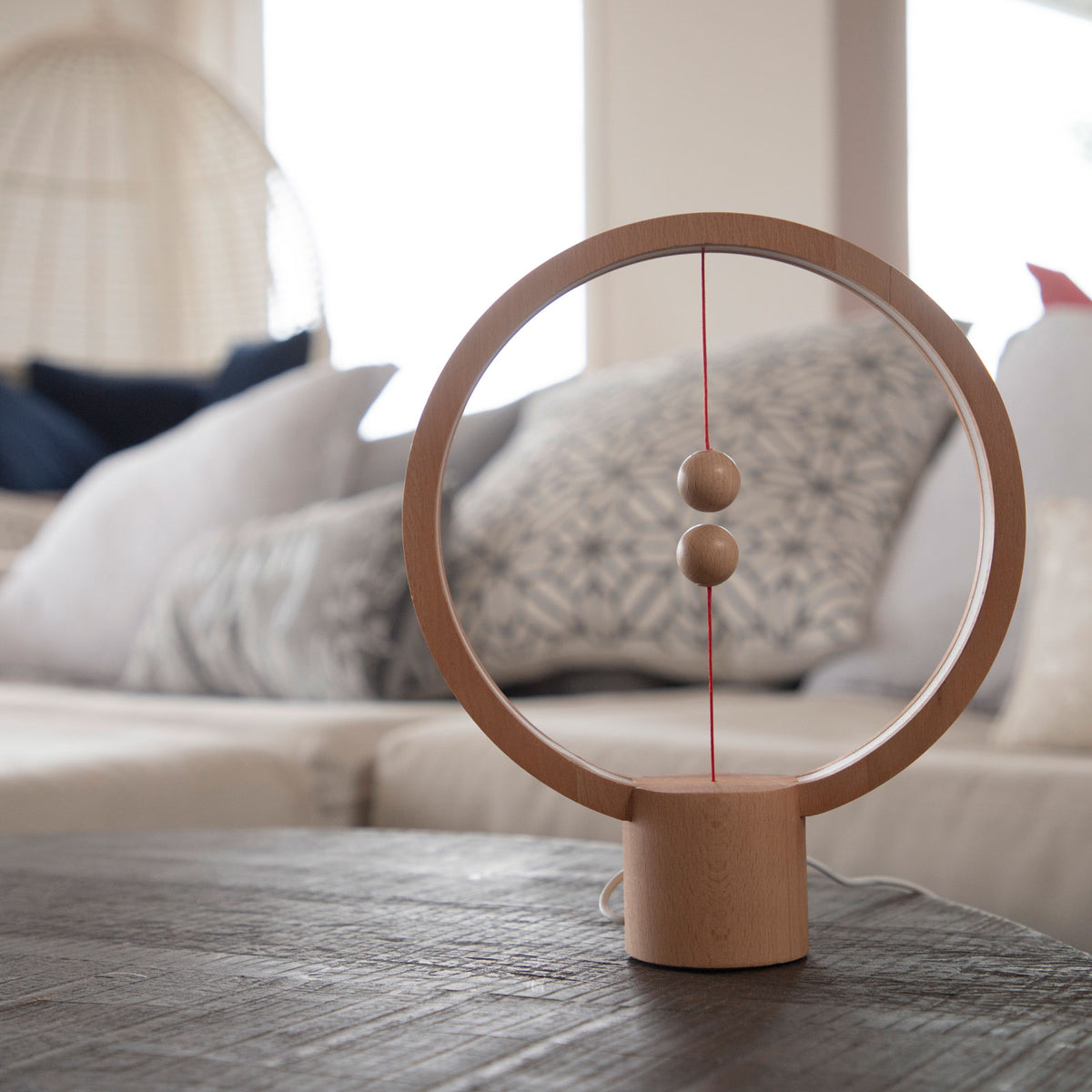 The Heng Round Light Wood on a living room table.