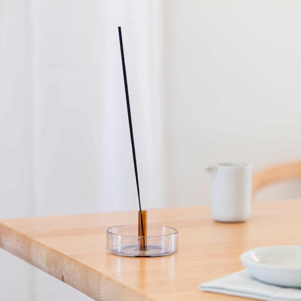 Incense holder with incense stick on table.