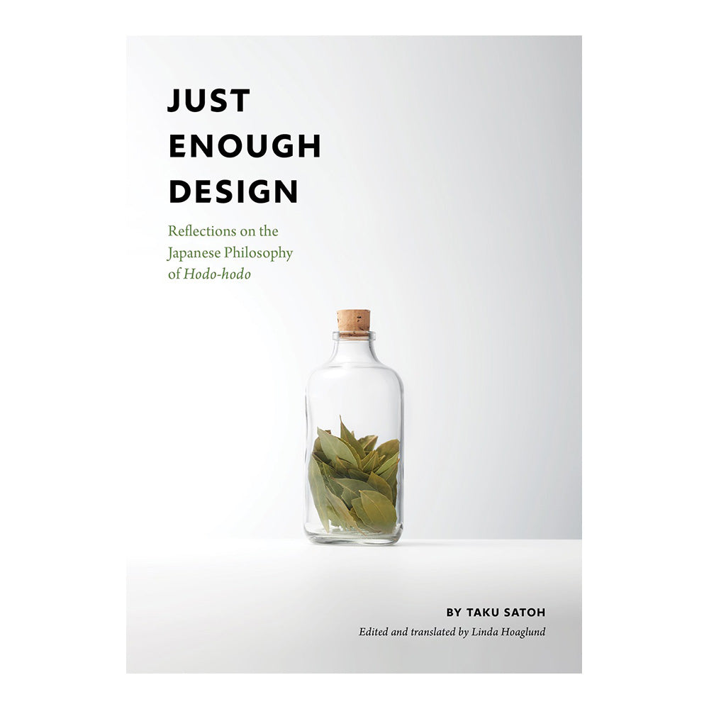 Cover of 'Just Enough Design'. Glass bottle with bay leaves closed with cork lid.