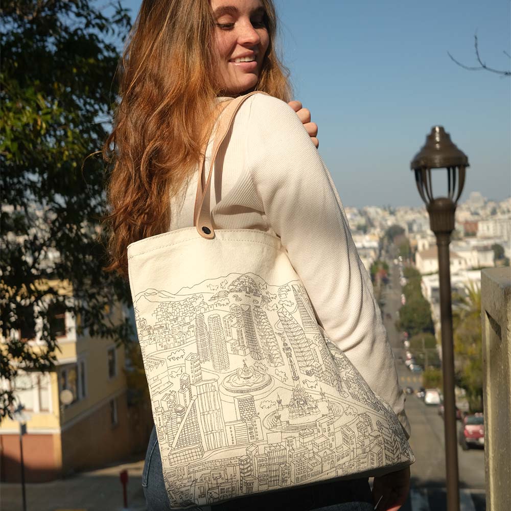 Model wearing Mexico City Tote by Paulina Sevilla x SFMOMA with a San Francisco hill in the background.