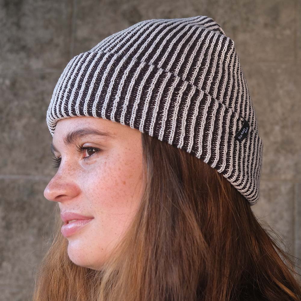 Model Wearing SFMOMA Rib Hat: Black + White in front of concrete background.