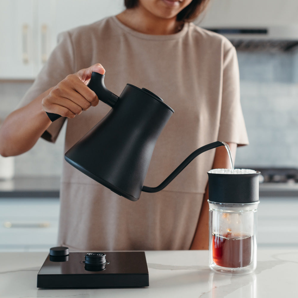Model pouring kettle over tea filter.