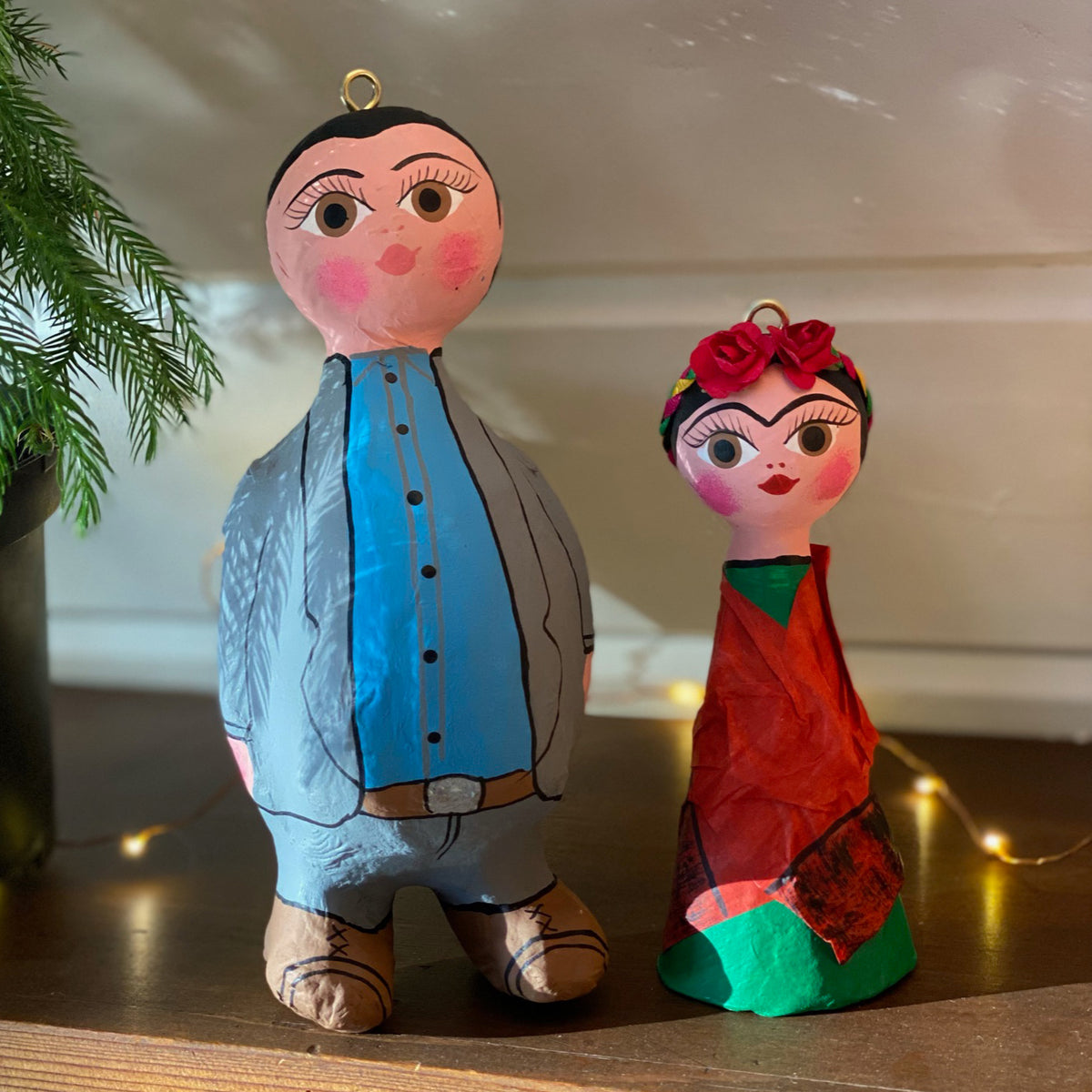 Tall Diego and Frida ornaments side by side on a table.