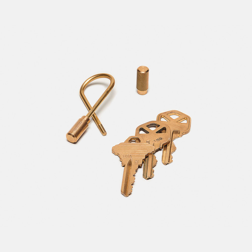 A Closed Helix Keyring: Brass displayed with keys with one fastener detached.