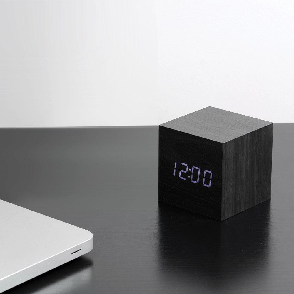 The Black Cube Click Clock displayed on a table.