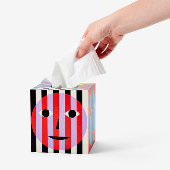 Hand pulling tissue out of the Everybody Tissue Box.