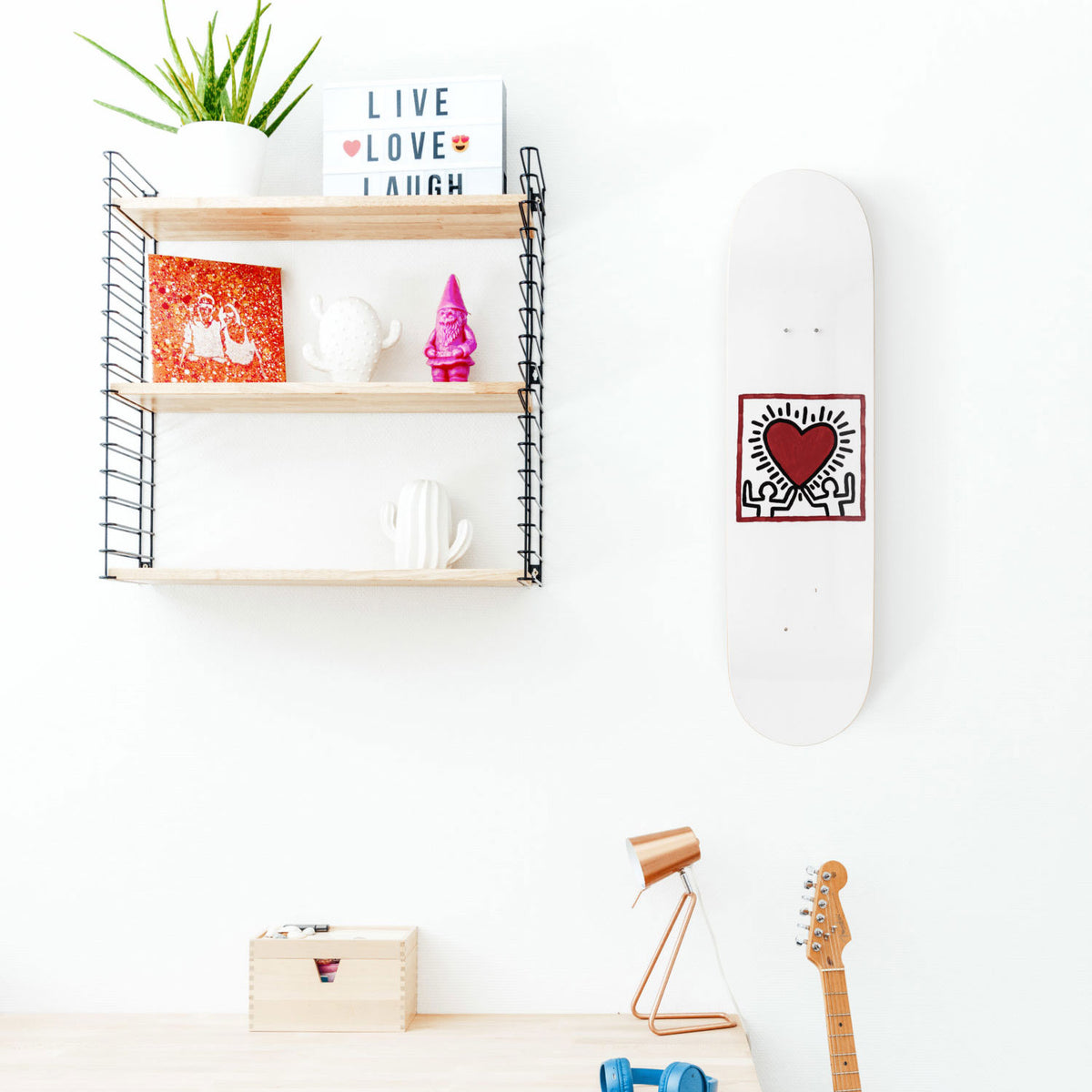The Keith Haring Heart Skateboard hanging in room.