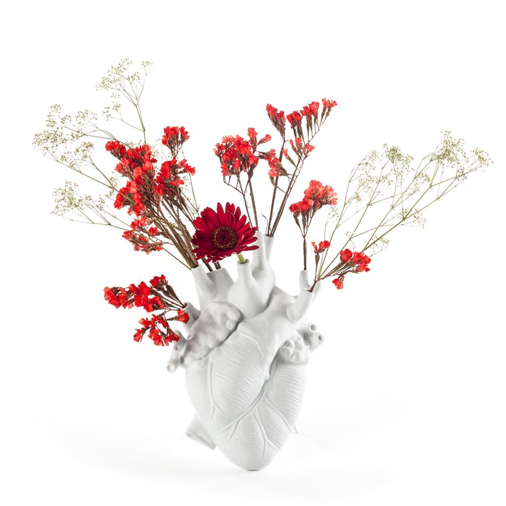 The Porcelain Heart Vase: White displayed with flowers.