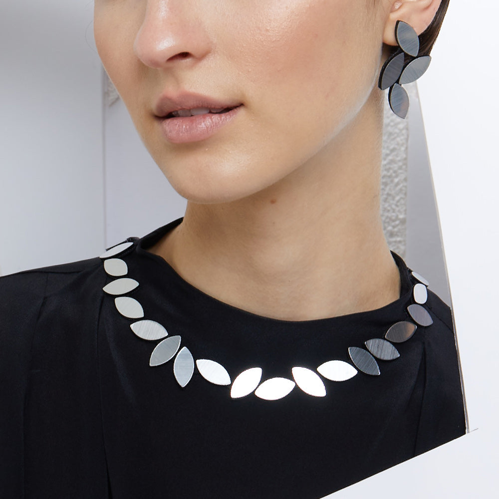 Close-up model wearing necklace over crew blouse.
