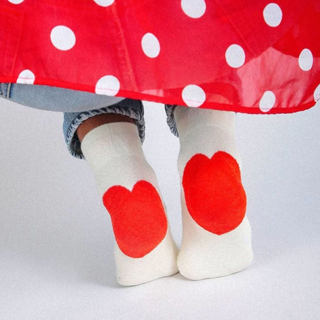 Model in Love You Socks, eggshell with red heart on heels, with jeans and red polka dot blouse.