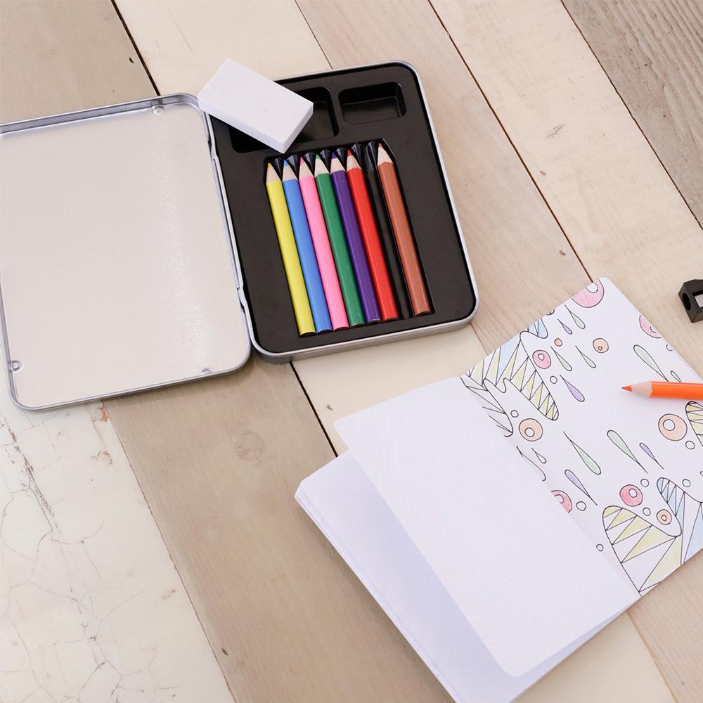 An opened Mini Doodle Kit displaying its included paper, colored pencils, pencil sharpeners and eraser.