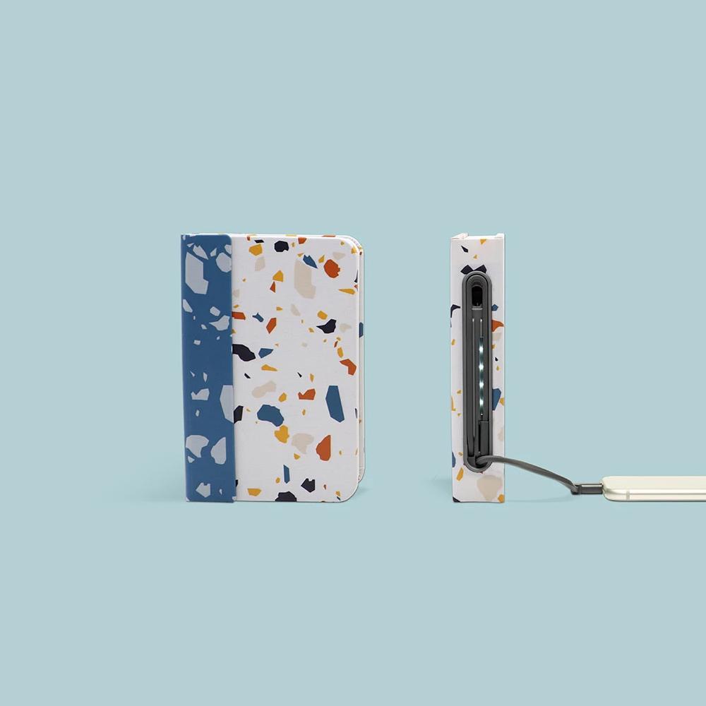 Two Lito Mini: Terrazzo displayed with one plugged into a phone via its USB charger.