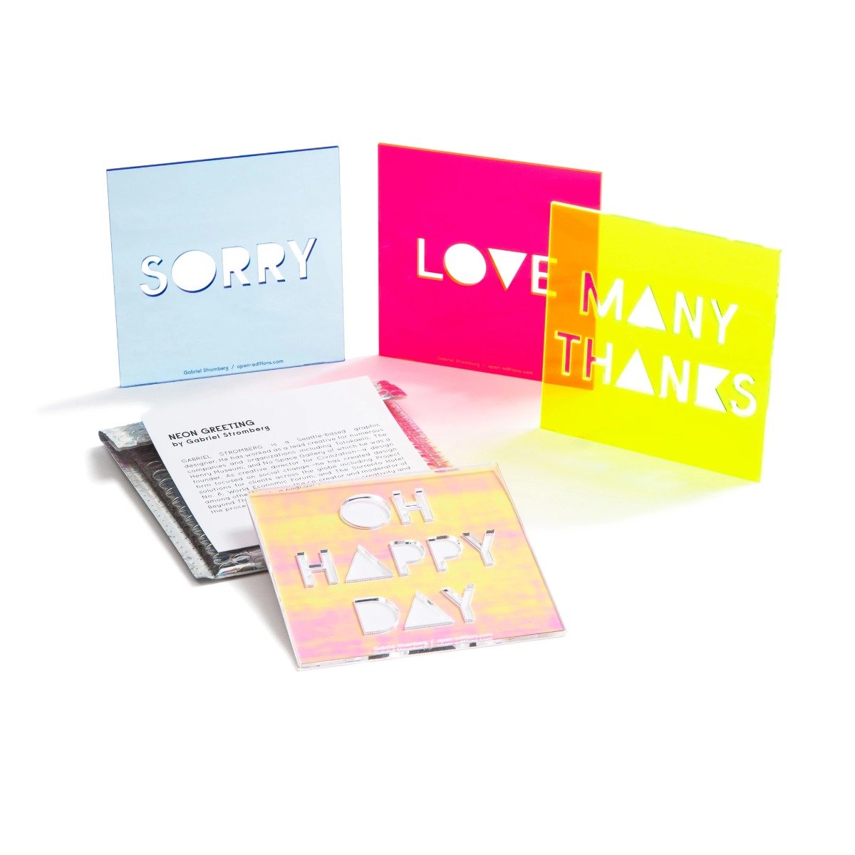 The Oh Happy Day Neon Greeting Card displayed with its packaging and other neon cards.