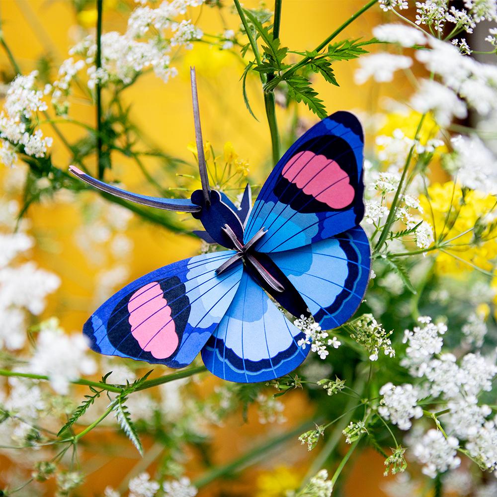 Peacock Butterfly Construction Kit&#39;s fully assembled butterfly displayed on flowers.