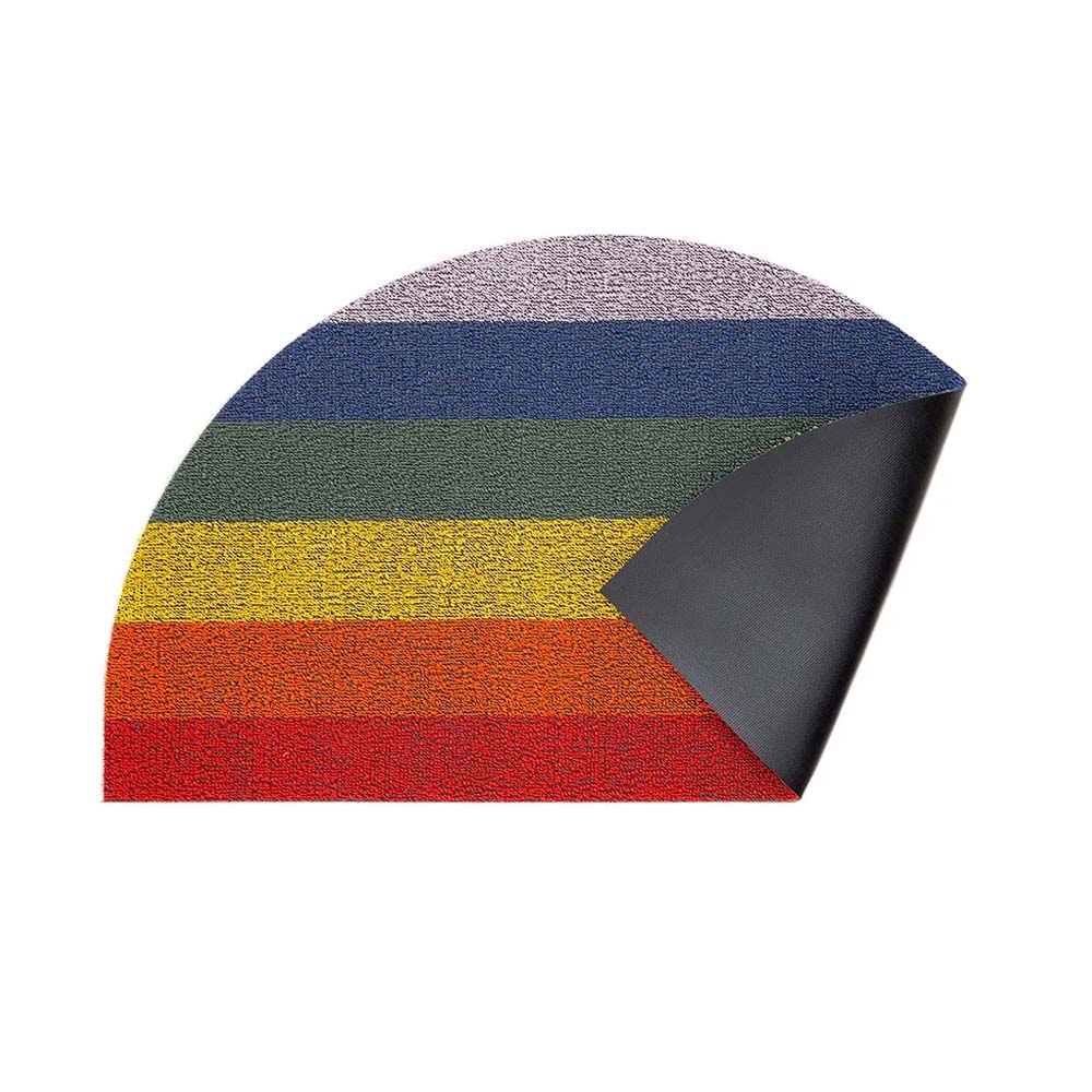 Semicircle rainbow doormat on white hardwood floors with white sneakers laying on top.