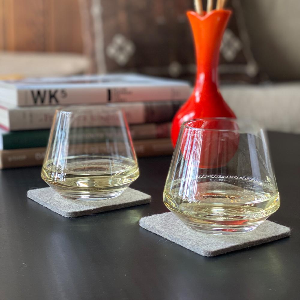 Two Pure Wine Tumblers with wine displayed on a table.