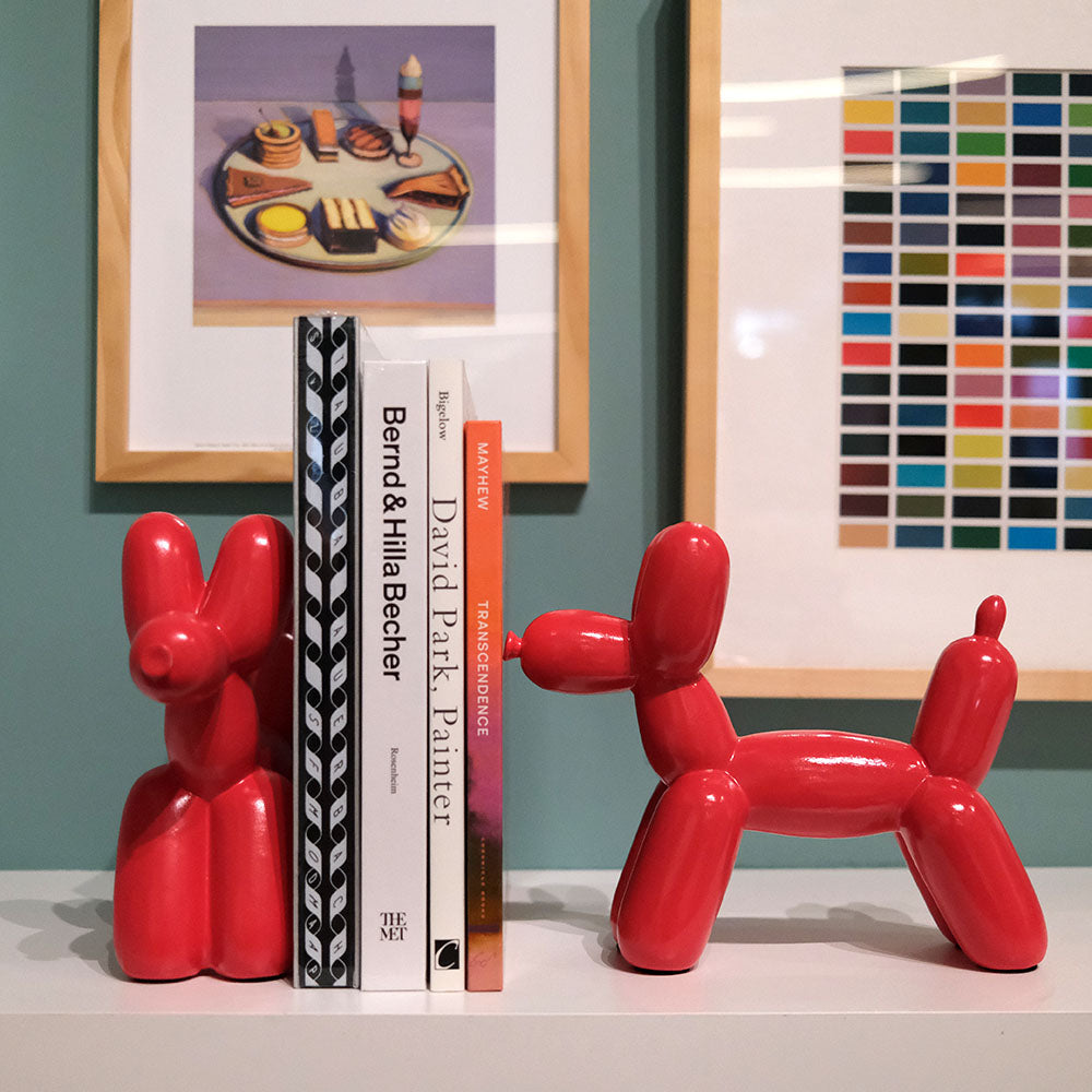 Two Red Balloon Dog Bookends holding up four art books at Steps Cafe.