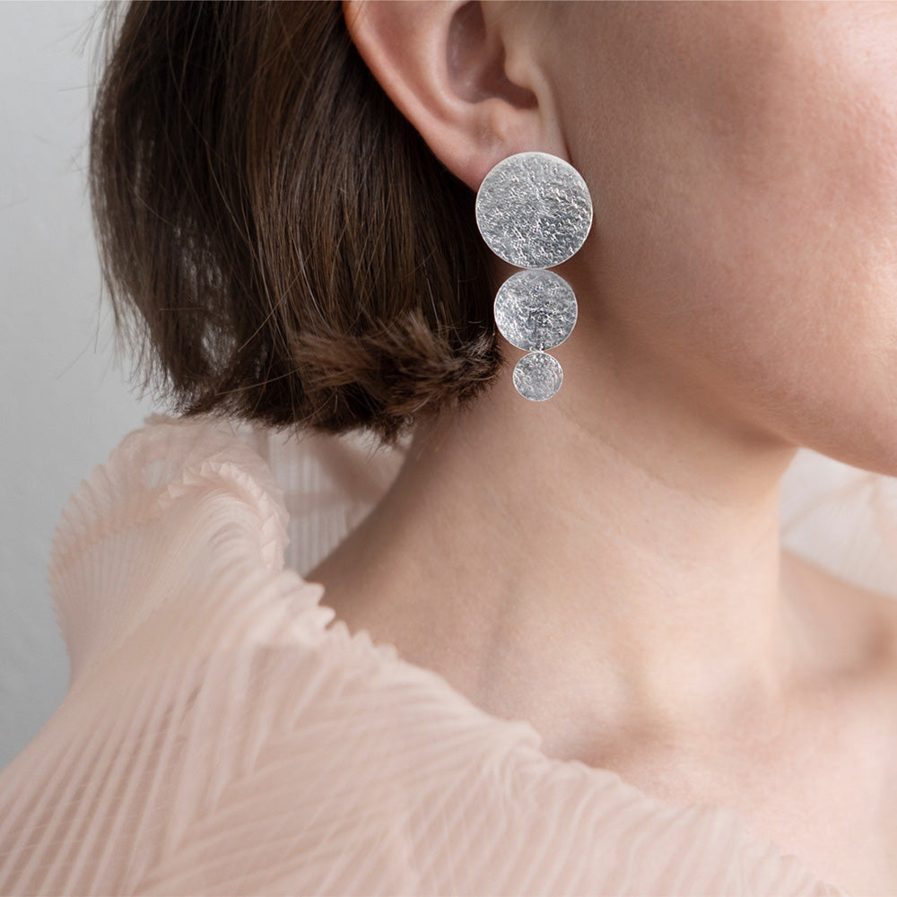 Small Asymmetrical Discs Earrings, three increasingly large silver disks. And three increasingly small disks.