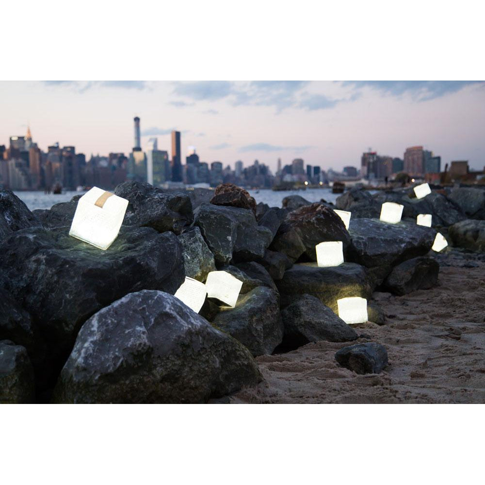 Several lit SolarPuffs on the shoreline of a city.
