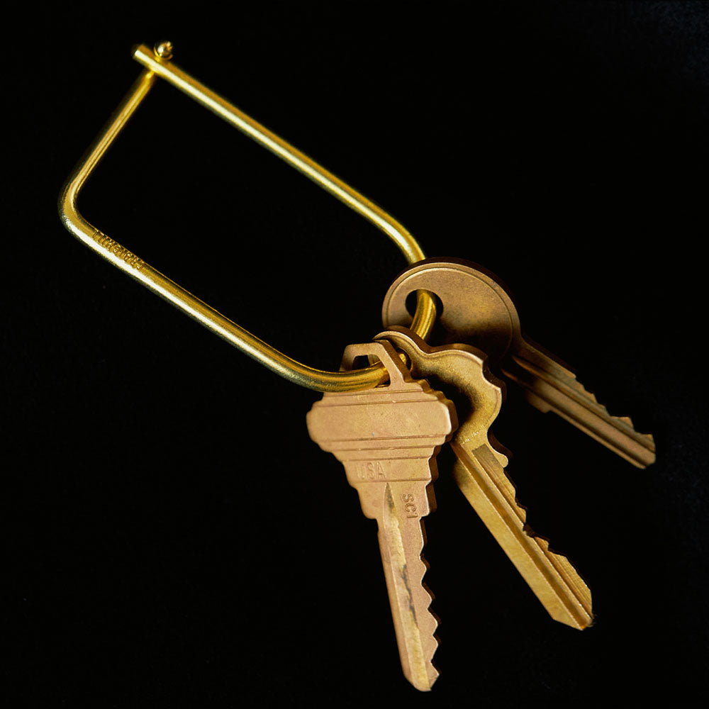 A close up of a Wilson Keyring: Brass holding three keys.