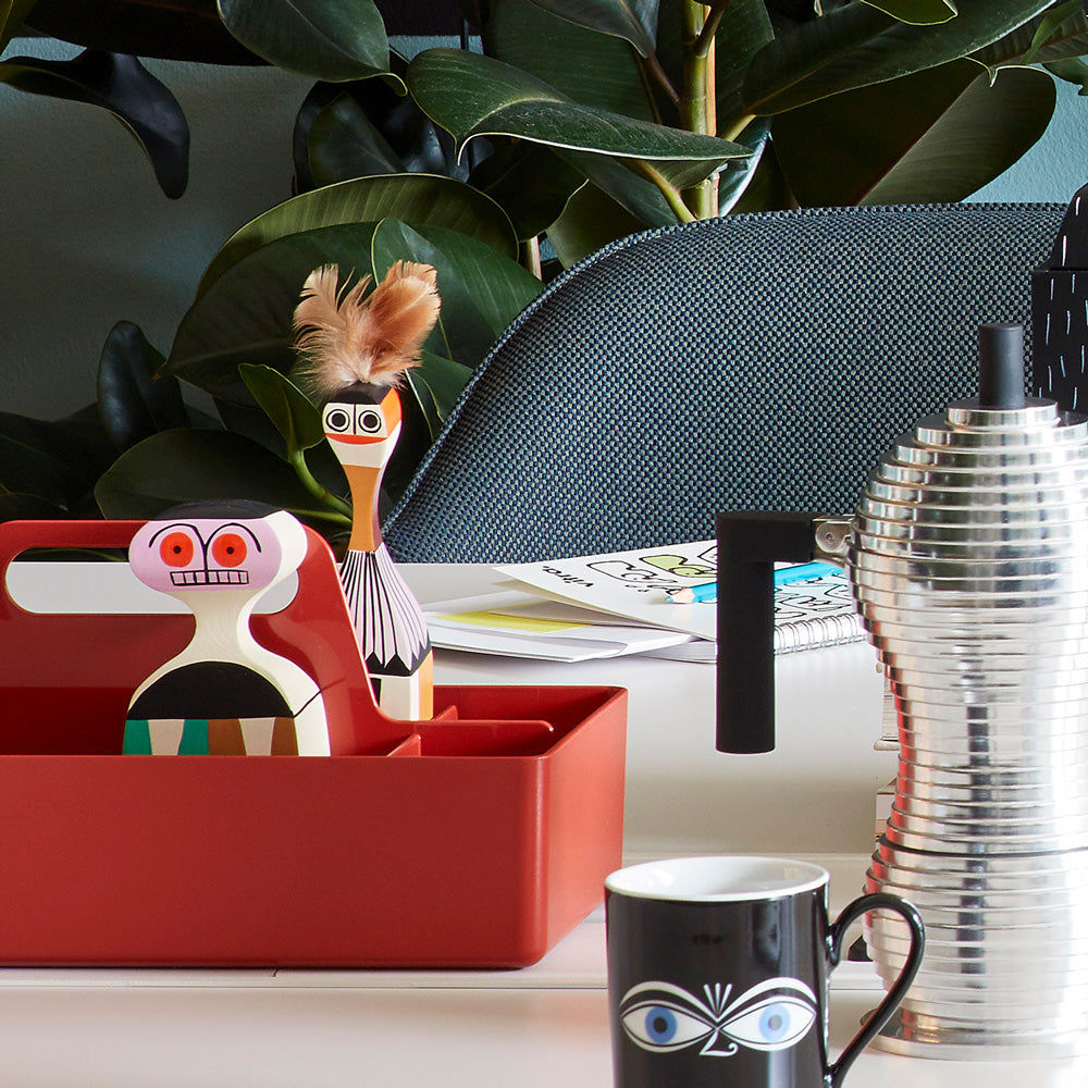 Two different wooden dolls on desk with other Vitra products.
